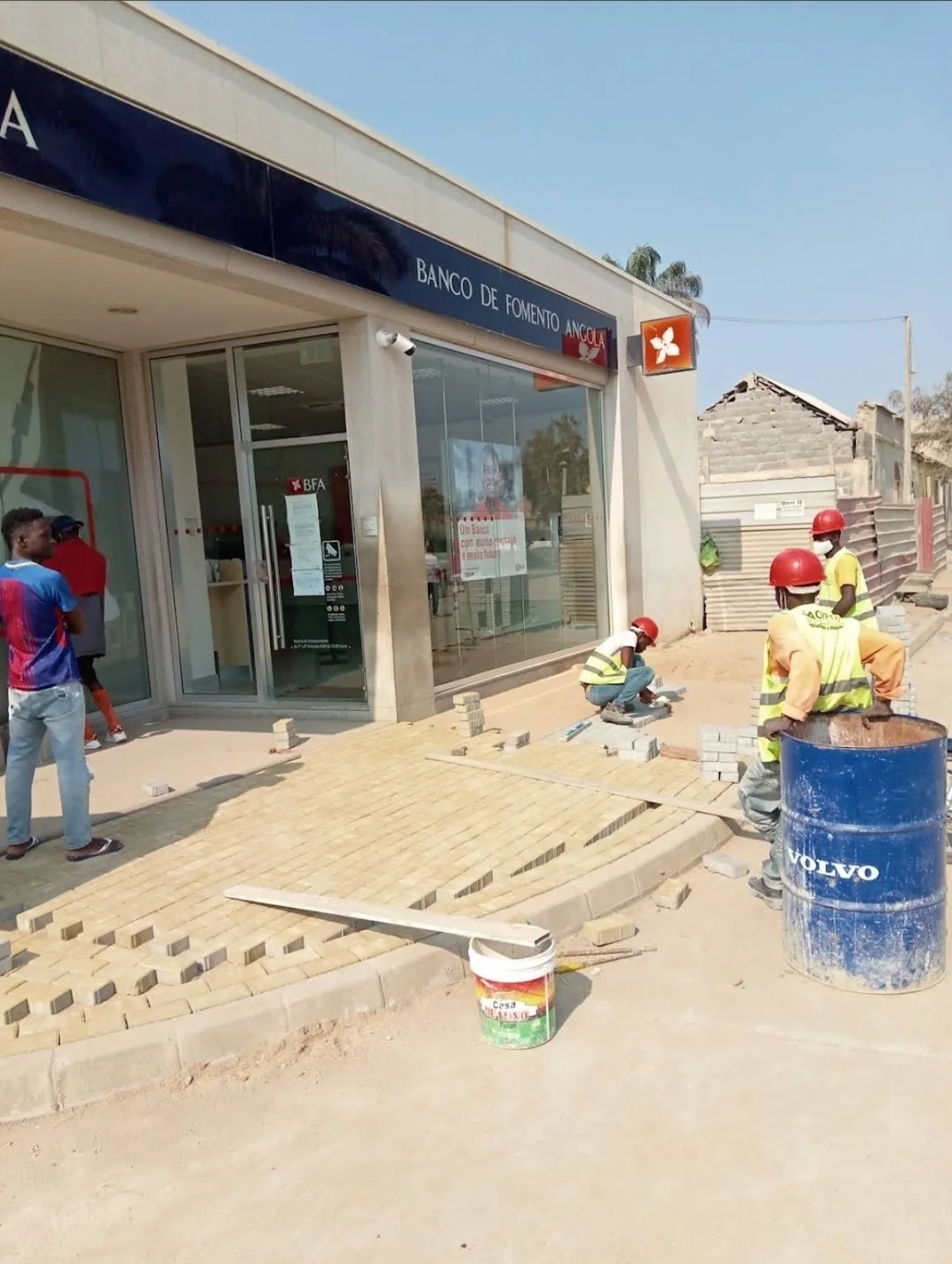 Trabalhos de pavimentação e acabamento realizados junto a um edifício